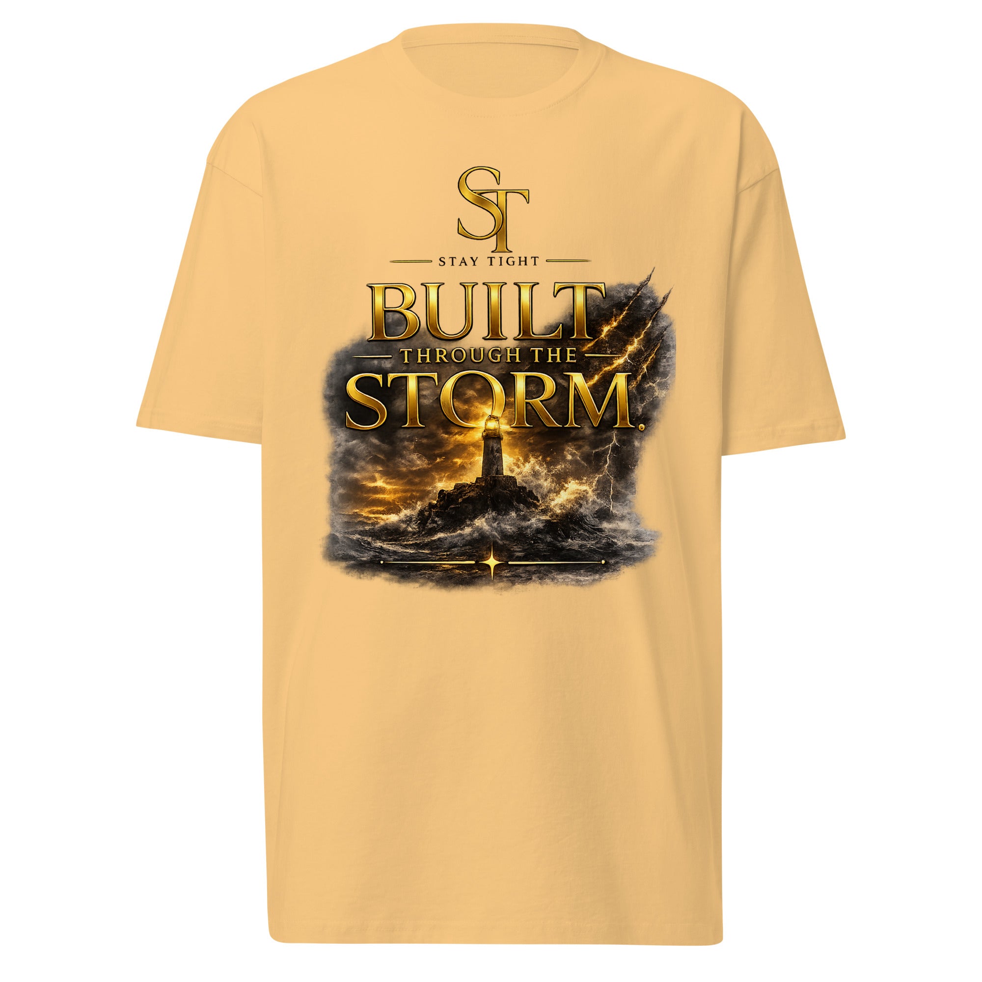 Stay Tight premium heavyweight T-shirt featuring the inspirational message "Built Through the Storm" with a lighthouse standing against crashing waves and storm clouds beneath the ST logo, symbolizing resilience, perseverance, courage, hope, and strength through adversity