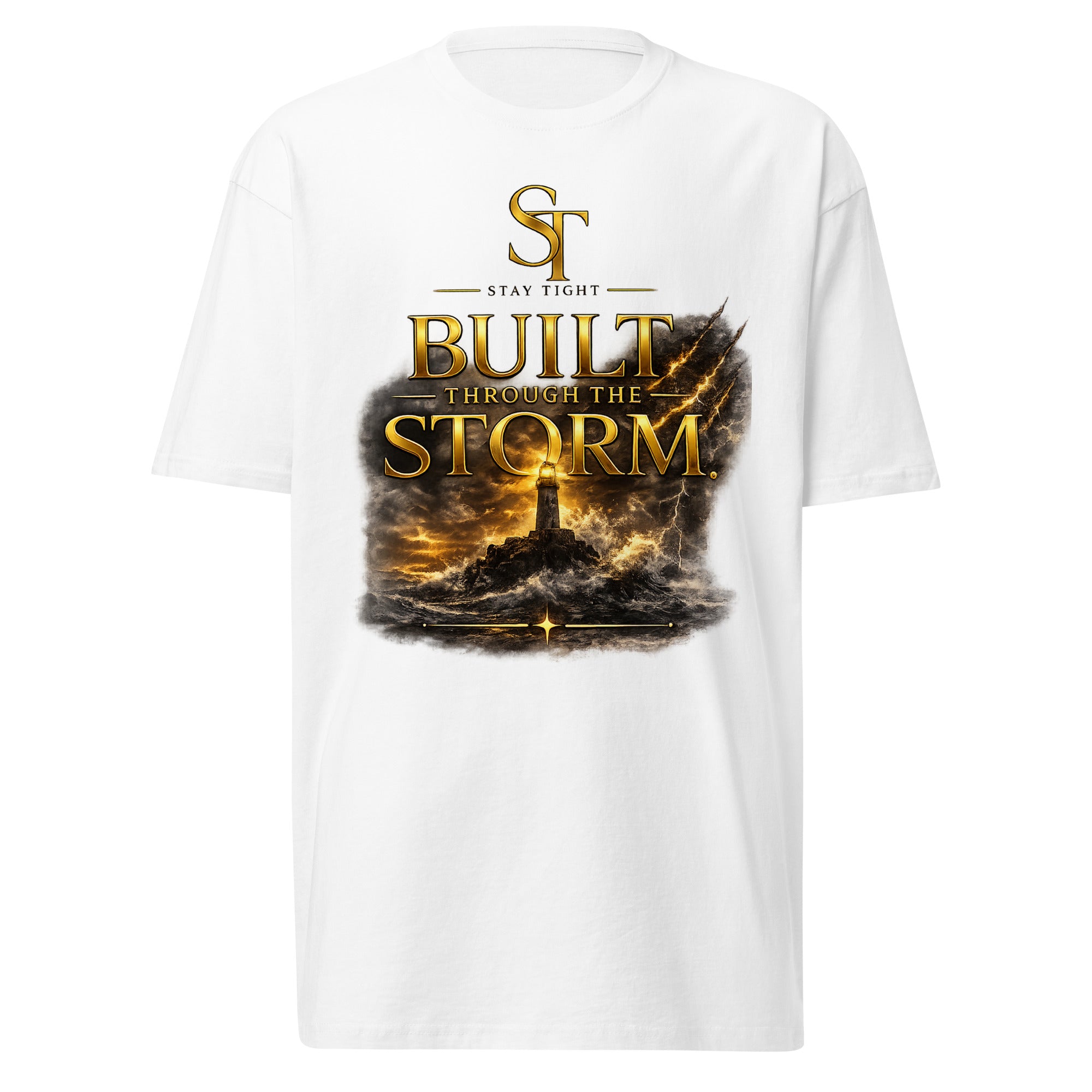 Stay Tight premium heavyweight T-shirt featuring the inspirational message "Built Through the Storm" with a lighthouse standing against crashing waves and storm clouds beneath the ST logo, symbolizing resilience, perseverance, courage, hope, and strength through adversity